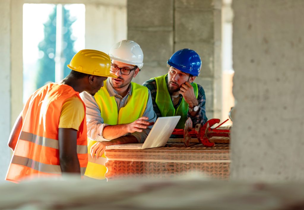 Government and public sector construction professionals reviewing plans on an institutional project site in Houston